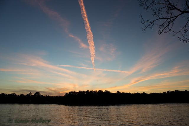 Sunset over Lake Jacksonville, Texas, with calm water, tree-lined shoreline, and colorful clouds